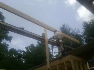 Carpenter setting a ridge beam over a new addition frame — Ice Dam Removal by Roofing Brothers in Amity